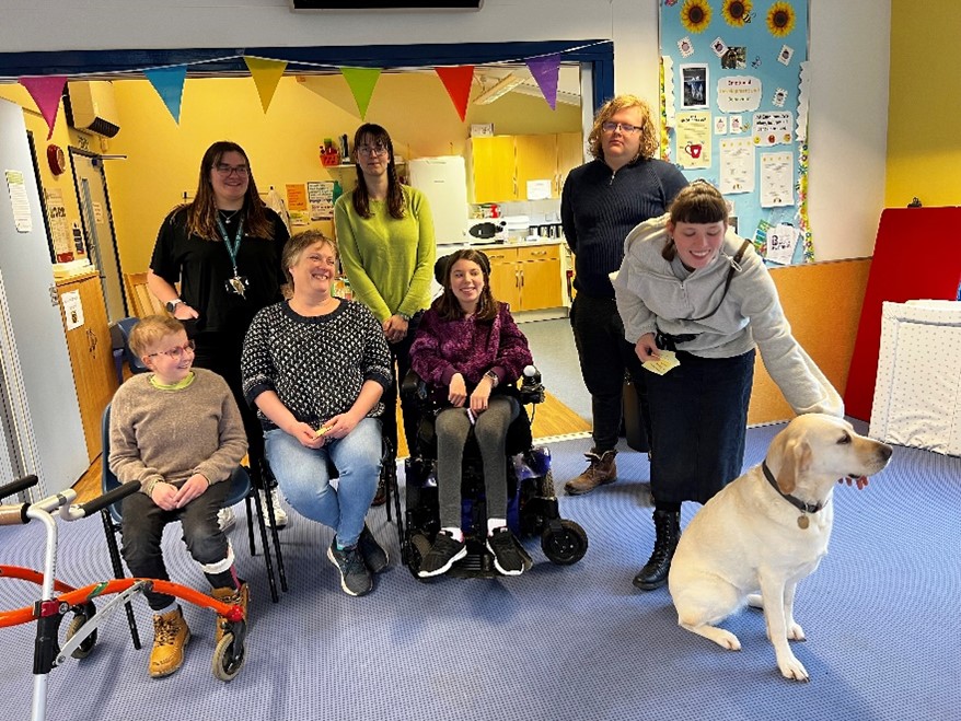 group of people smiling with a dog