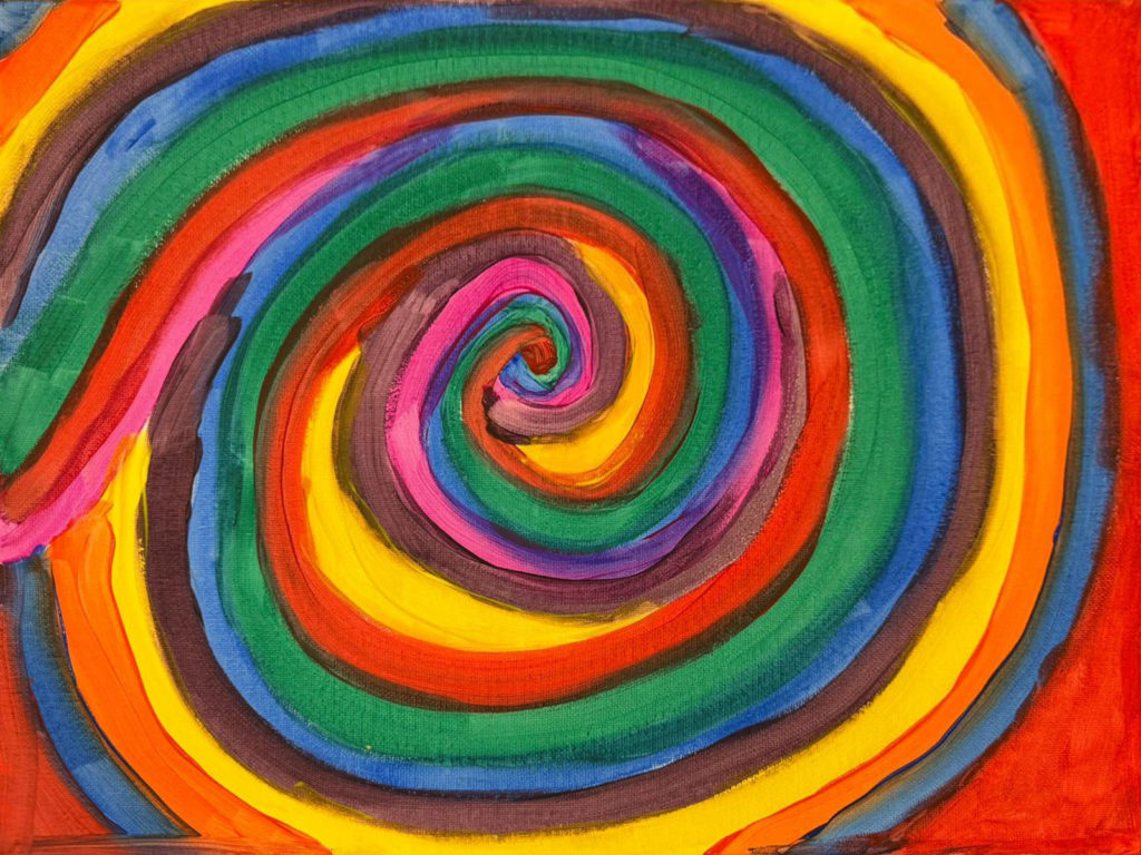 A rainbow swirl of colours painted on a canvas